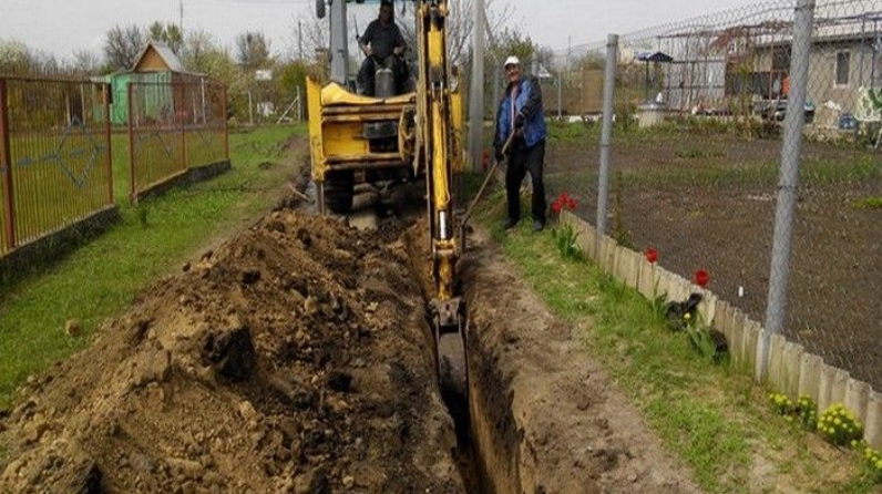 Под водопровод. Техника для копки траншеи под водопровод. Прокопать траншею под водопровод. Прокоп траншеи для водопровода. Траншея для прокладки водопровода.